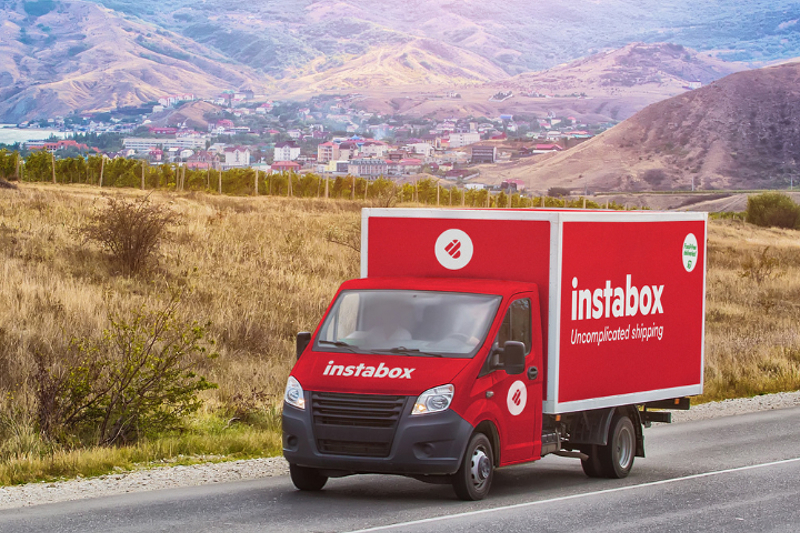 Instabox bil med leverans av paket på väg