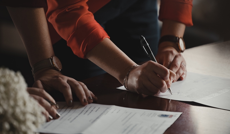 Händer som skriver under på dokument